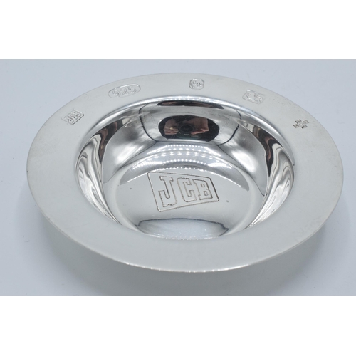 111 - Silver pin dish / ash tray engraved with 'JCB' logo, 64.0 grams, Birmingham 2000, 10cm diameter.