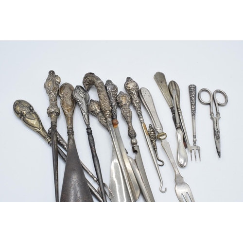 113 - A good collection of silver-handled items to include scissors, knives, button hooks etc (Qty).