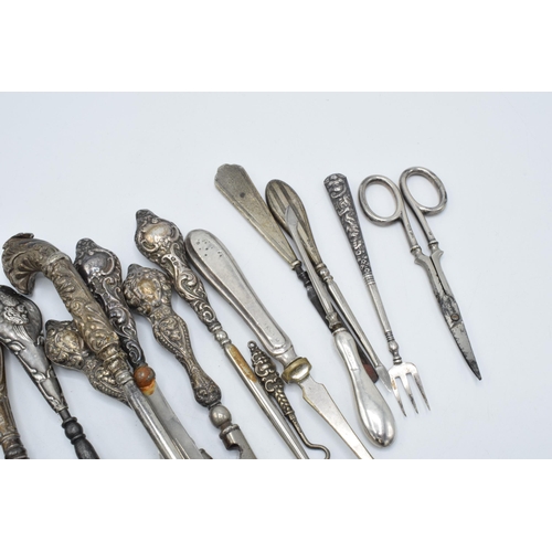 113 - A good collection of silver-handled items to include scissors, knives, button hooks etc (Qty).