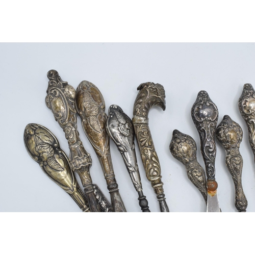 113 - A good collection of silver-handled items to include scissors, knives, button hooks etc (Qty).