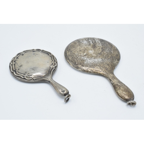 115 - A pair of miniature silver hand mirrors, largest 11cm long, hallmarks rubbed (2).