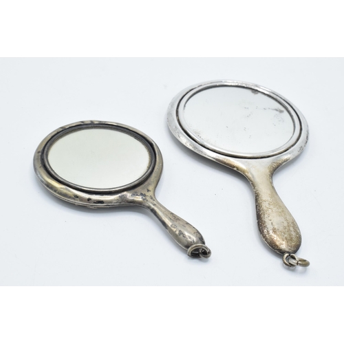 115 - A pair of miniature silver hand mirrors, largest 11cm long, hallmarks rubbed (2).