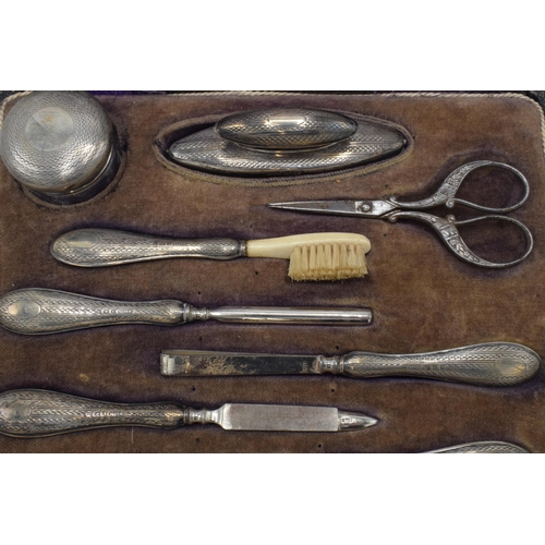 122 - Silver handled manicure set with 8 pieces to include a nail buffer, lidded jar, nail file and others... 