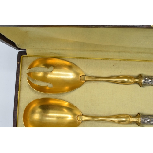 123 - A cased pair of late 19th century silver and gilt metal salad servers, probably European, with indis... 