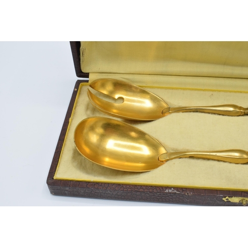 123 - A cased pair of late 19th century silver and gilt metal salad servers, probably European, with indis... 