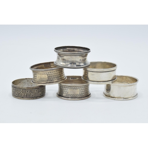 125 - A collection of hallmarked silver napkin rings with varying designs, 59.6 grams (6).