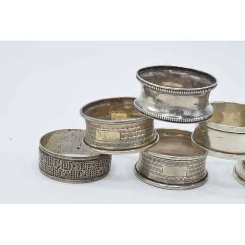 125 - A collection of hallmarked silver napkin rings with varying designs, 59.6 grams (6).