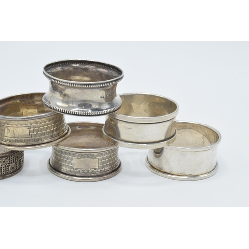 125 - A collection of hallmarked silver napkin rings with varying designs, 59.6 grams (6).