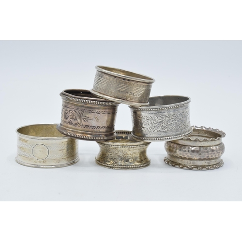 126 - A collection of hallmarked silver napkin rings of varying ornate designs, 76.0 grams (6).