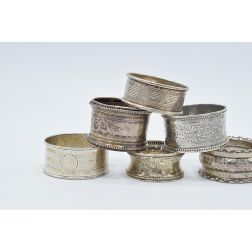 126 - A collection of hallmarked silver napkin rings of varying ornate designs, 76.0 grams (6).