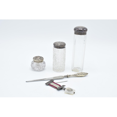 131 - A trio of silver topped scent bottles together with silver handled knife and a medal with a silver b... 