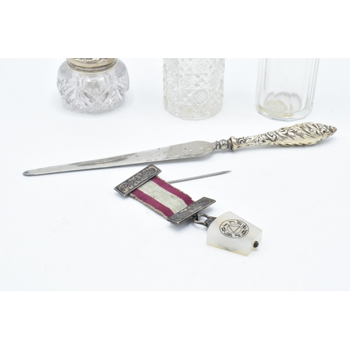 131 - A trio of silver topped scent bottles together with silver handled knife and a medal with a silver b... 