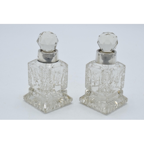 193 - A pair of silver collared glass perfume bottles, Birmingham 1908, H C Davis, 10cm tall (2).