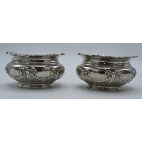 199 - A pair of silver table salts with embossed decoration of a bow and similar, London 1897, 80.4 grams,... 