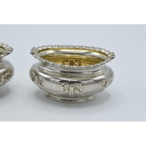 199 - A pair of silver table salts with embossed decoration of a bow and similar, London 1897, 80.4 grams,... 