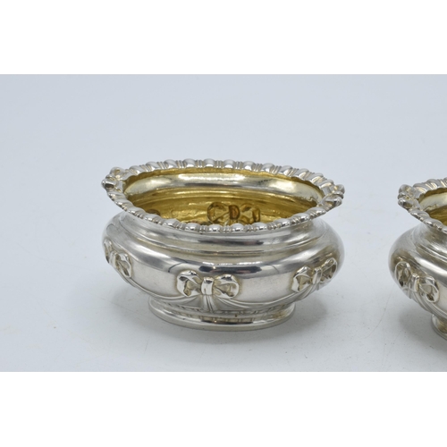 199 - A pair of silver table salts with embossed decoration of a bow and similar, London 1897, 80.4 grams,... 