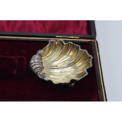 209 - A cased pair of silver shell salt dishes in velvet and fabric lined case, 15.0 grams.