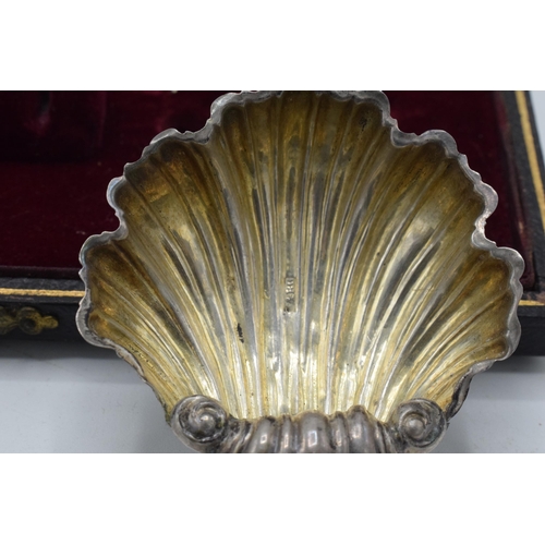 209 - A cased pair of silver shell salt dishes in velvet and fabric lined case, 15.0 grams.