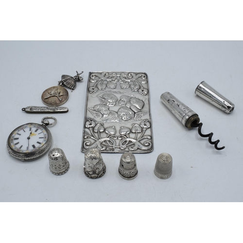 211 - A collection of silver items to include a sterling silver cased corkscrew, a silver Reynold's Angels... 