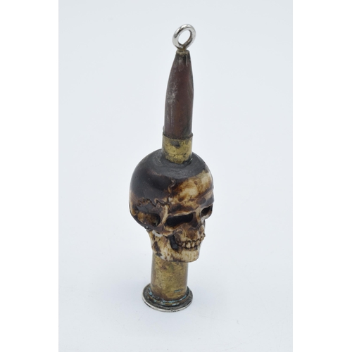 248 - Vintage Trench Art of a carved bone in the form of a skull with an ammunition shell, 9cm tall, mount... 