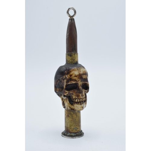 248 - Vintage Trench Art of a carved bone in the form of a skull with an ammunition shell, 9cm tall, mount... 