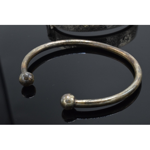 299 - A collection of silver jewellery to include a silver hollow hinged bangle, a torque bangle, part sil... 