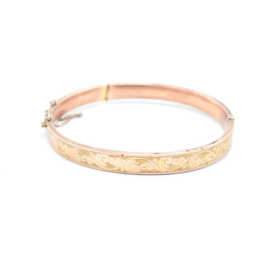 318 - 9ct rose gold bangle with engraved decoration, 8.8 grams, split to rear, 65mm diameter.