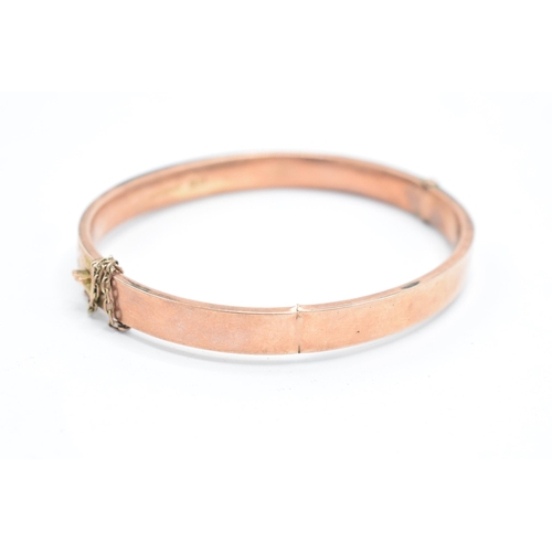 318 - 9ct rose gold bangle with engraved decoration, 8.8 grams, split to rear, 65mm diameter.