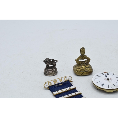 332 - A collection of items to include a white metal chain fob / seal, a brass example, silver riding crop... 