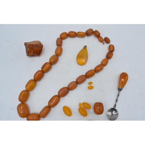 336 - A collection of butterscotch amber (or similar) items to include raw block, a graduated necklace and... 