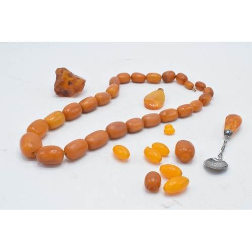 336 - A collection of butterscotch amber (or similar) items to include raw block, a graduated necklace and... 