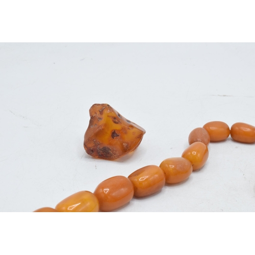 336 - A collection of butterscotch amber (or similar) items to include raw block, a graduated necklace and... 