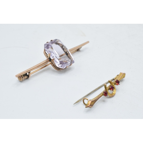 338 - A pair of 9ct gold bar brooches, one with a horseshoe set with garnets, base metal pin, together wit... 