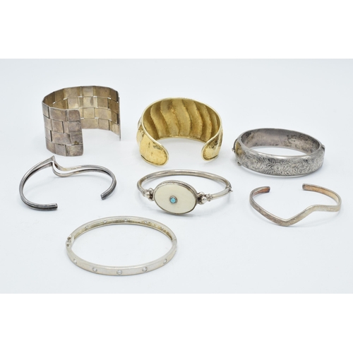 374 - A good collection of silver bangles and bracelets to include a silver gilt example, a chunky brick-e... 