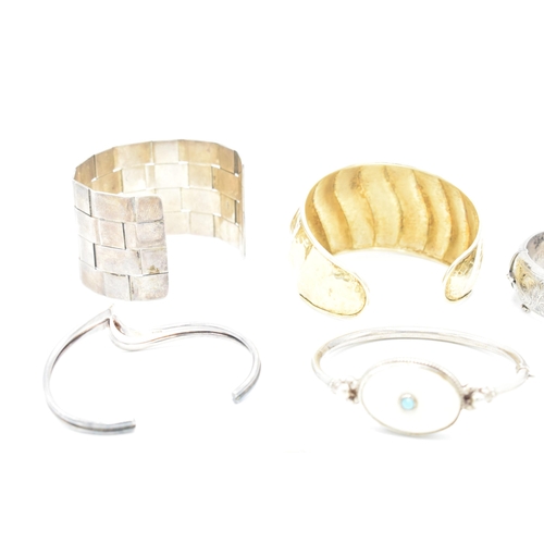 374 - A good collection of silver bangles and bracelets to include a silver gilt example, a chunky brick-e... 