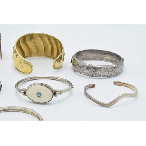 374 - A good collection of silver bangles and bracelets to include a silver gilt example, a chunky brick-e... 