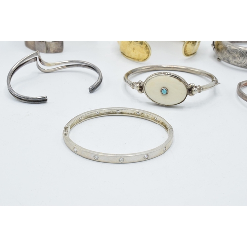 374 - A good collection of silver bangles and bracelets to include a silver gilt example, a chunky brick-e... 