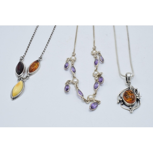 382 - A trio of silver ladies necklaces with pendants to include amber-style items and amethyst coloured s... 