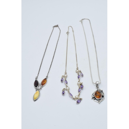 382 - A trio of silver ladies necklaces with pendants to include amber-style items and amethyst coloured s... 