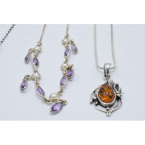 382 - A trio of silver ladies necklaces with pendants to include amber-style items and amethyst coloured s... 