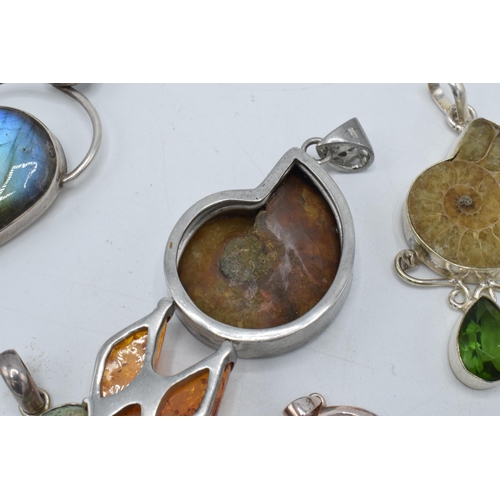 383 - An interesting collection of silver pendants with various gemstones and similar materials of varying... 