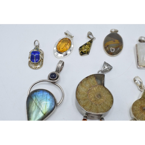 383 - An interesting collection of silver pendants with various gemstones and similar materials of varying... 