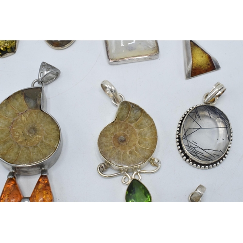 383 - An interesting collection of silver pendants with various gemstones and similar materials of varying... 