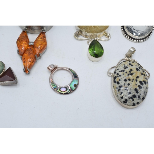 383 - An interesting collection of silver pendants with various gemstones and similar materials of varying... 