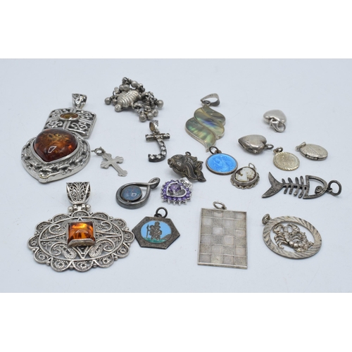 385 - An interesting collection of silver pendants and charms to include a fish, small hearts, fob-style i... 