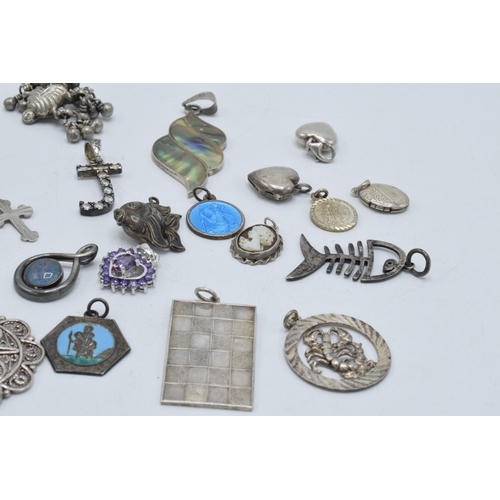 385 - An interesting collection of silver pendants and charms to include a fish, small hearts, fob-style i... 