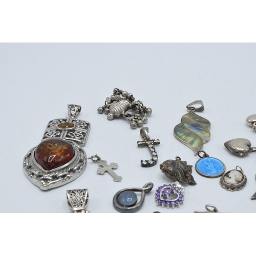 385 - An interesting collection of silver pendants and charms to include a fish, small hearts, fob-style i... 