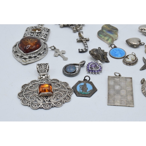 385 - An interesting collection of silver pendants and charms to include a fish, small hearts, fob-style i... 