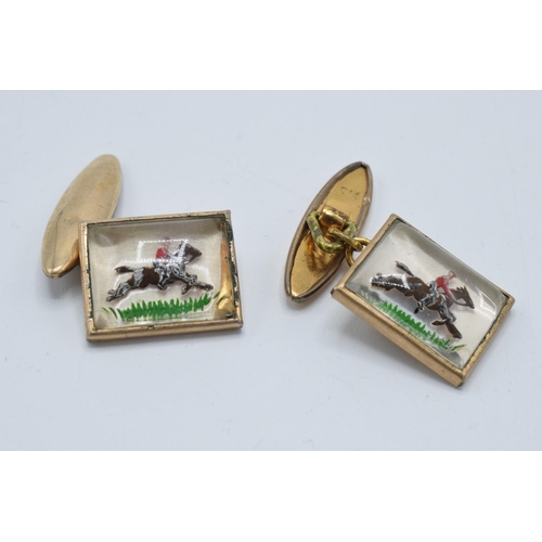 386 - A pair of cufflinks with enamelled decorations of racehorses (2).