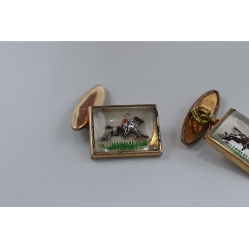 386 - A pair of cufflinks with enamelled decorations of racehorses (2).